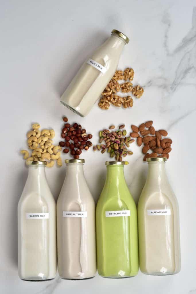 This may contain: four bottles with nuts and milk in them
